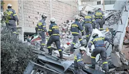  ?? VISAR KRYEZIU/AP ?? Rescuers from Romania go over debris at a collapsed building in western Albania.