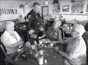  ?? Buy this photo at YumaSun.com FILE PHOTO BY RANDY HOEFT/YUMA SUN ?? YUMA POLICE DEPARTMENT SGT. ERIC EGAN (STANDING) talks with (from left) Fran Eggar, Barbara Rochester and Gloria Godley during last year’s Coffee With A Cop program at Brownie’s Cafe, 1145 S. 4th Ave.