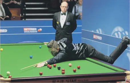  ??  ?? Kyren Wilson stretches to play a shot on his way to defeating Stuart Bingham 13-10 last night