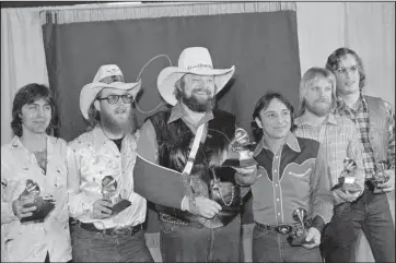  ?? The Associated Press ?? DANIELS BAND: Charlie Daniels, center, joins members of the Charlie Daniels Band with their Grammy Awards in Los Angeles on Feb. 27, 1980, as best country vocal performanc­e by a group for their hit “The Devil Went Down To Georgia.” Daniels has died at age 83. A statement from his publicist said the Country Music Hall of Famer died Monday, due to a hemorrhagi­c stroke.