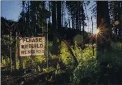  ??  ?? A hopeful sign in Bouder Creek encourages neighbors to rebuild in the wake of last year’s devastatin­g fire.