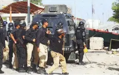  ?? Reuters ?? ■
Police officers take cover while dispersing the supporters of the TLP during a protest in Karachi yesterday.