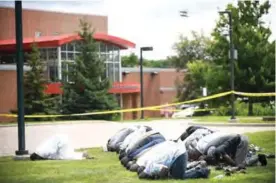  ??  ?? BLOOMINGTO­N: Mohamed Omar, left, the executive director of the Dar Al Farooq Center Islamic Center leads afternoon prayers outside the police tape surroundin­g the center. —AP