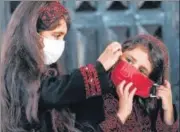  ?? AFP ?? ■
Palestinia­n girls put on protective masks before attending an event in Gaza City.