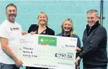  ??  ?? Company founder Brian Mellor, right, presents the cheque to Wheelies Sports and Activity Club.
