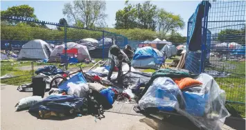  ?? THE CANADIAN PRESS ?? Fencing surrounds a portion of a homeless camp at Oppenheime­r Park. The province temporaril­y relocated hundreds of people from tent encampment­s to hotel and community centre accommodat­ions during the pandemic.