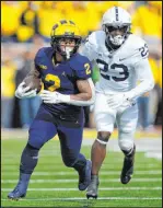  ?? Paul Sancya
The Associated Press ?? Michigan running back Blake Corum races past Penn State linebacker Curtis Jacobs in the Wolverines’ 41-17 win Saturday.