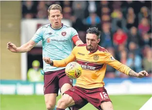  ??  ?? ■
Hearts’ Christophe Berra challenges Motherwell’s Ryan Bowman.