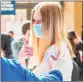  ??  ?? Above, Sadie Sindland, 14, gives a thumbs-up /after being inoculated at the Connecticu­t Convention Center in Hartford on Thursday.