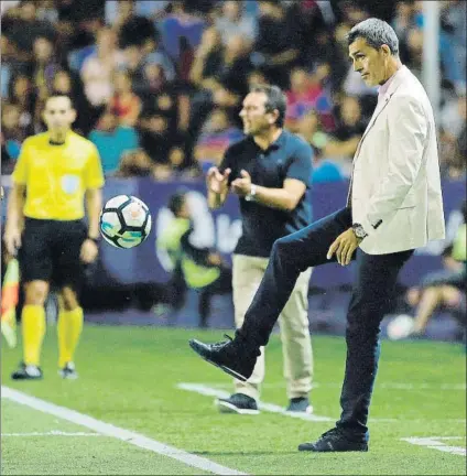  ?? FOTO: EFE ?? Eusebio Sacristán aplaude a sus jugadores al fondo de la imagen mientras Muñiz recuerda viejos tiempo, chutando el balón