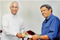  ??  ?? Sunrise Foundation chairman Feizal Samath presenting the ‘Sunrise’ Magazine to Minister Eran Wickramara­tne