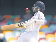  ??  ?? Cheteshwar Pujara gets hit on the helmet by a Pat Cummins bouncer during Day 5 of the Brisbane Test on Tuesday.