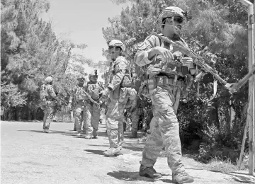  ??  ?? This file photo shows Afghan soldiers walking at the scene of clashes between Afghan security forces and Taliban militants in Helmand province. — AFP photo