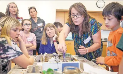  ?? PHOTOS BY GABRIELA CAMPOS/THE NEW MEXICAN ?? Susan Reynolds, a librarian’s assistant and leader of children’s art activities at the Southside Branch Library, leads a recent demonstrat­ion on the ancient Ukrainian and Polish tradition of egg decorating, called pysanky.