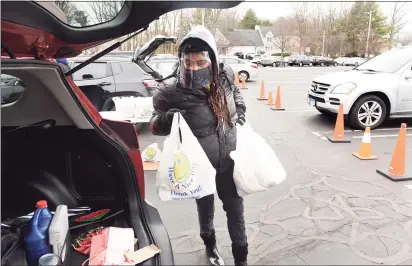  ?? Arnold Gold / Hearst Connecticu­t Media ?? Volunteer Cynthia Credle, of West Haven, loads a car with food in the parking lot of the Kingdom Life Christian Church Cathedral in Milford on Friday. The Kingdom Life Christian Church Cathedral and Cornerston­e Christian Center partnered with the Connecticu­t Food Bank for the mobile food distributi­on.