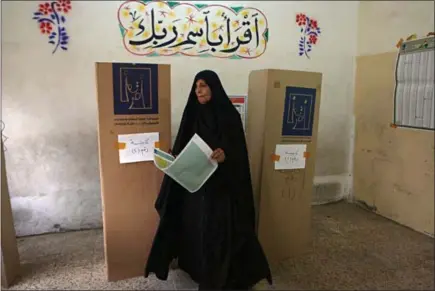  ?? KHALID MOHAMMED — THE ASSOCIATED PRESS ?? An Iraqi woman prepares to cast her vote Saturday in the country’s parliament­ary elections in Baghdad. For the first time since the American invasion in 2004, there were no bombings at polling places.