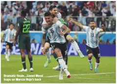  ??  ?? Dramatic finale...Lionel Messi leaps on Marcos Rojo’s back