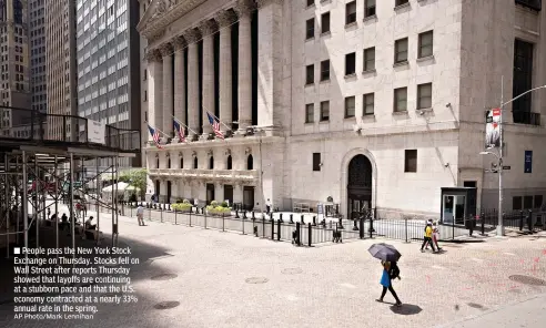  ?? AP Photo/Mark Lennihan ?? ■ People pass the New York Stock Exchange on Thursday. Stocks fell on Wall Street after reports Thursday showed that layoffs are continuing at a stubborn pace and that the U.S. economy contracted at a nearly 33% annual rate in the spring.