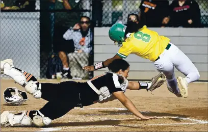  ?? PHOTOS BY JOEL ROSENBAUM — THE REPORTER ?? Vanden High’s Shawnese Hogue-Lacy leaps as she tries to avoid the tag by Vacaville High catcher Makayla Freshour during the third inning of the Vikings’ 3-1 victory over the Bulldogs Wednesday at Vanden High. Hogue was called out on the play.
