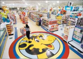  ?? Daniel Hulshizer The Associated Press file ?? Toys R Us mascot Geoffrey the giraffe in a 1996 file photo of a woman shopping at one of the company’s stores in Raritan, N.J.