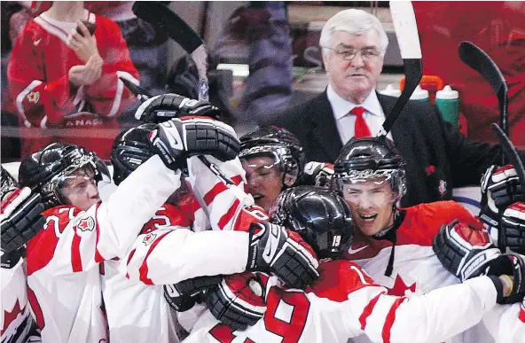  ?? — THE CANADIAN PRESS FILES ?? The late Pat Quinn, who was head coach at the time for Team Canada, looks on as John Tavares is mobbed by teammates after scoring the game-winning goal on Team Russia goalie Danila Alistratov during a semifinal shootout in the 2009 world junior...