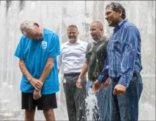  ??  ?? One positive from the CEO Soak, other than the money it raises, is that it came on a blistering hot day Thursday. Here, from left, Fred Abercrombi­e, Christophe­r Wick, Peter Pomager and Manuel Laura cool off in the fountain.