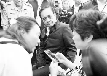  ?? — Reuters photo ?? Prayuth Chan-ocha sits next to a relative of Chinese tourists involved in a sunken tourist boat accident at a hospital in Phuket,Thailand.