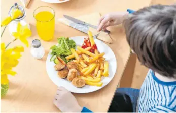  ?? FOTO: TOBIAS HASE/DPA ?? Limonade, Chicken Nuggets und Pommes Frites sind ungesund. Bundesernä­hrungsmini­sterin Julia Klöckner will den Anteil von Zucker, Salz und Fett in Gerichten für Kinder weiter senken.