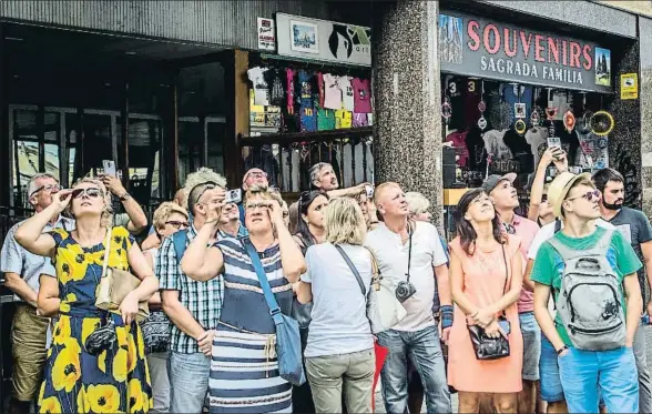  ?? LLIBERT TEIXIDÓ ?? Turistas toman la acera de Provença para inmortaliz­ar la Sagrada Família; algunos alargarán su visita a la zona comprando souvenirs