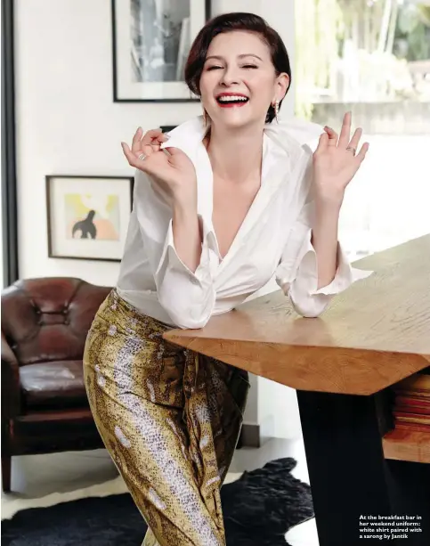  ??  ?? At the breakfast bar in her weekend uniform: white shirt paired with a sarong by Jantik