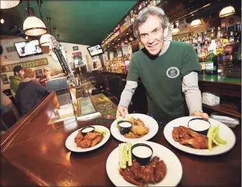  ?? Hearst Connecticu­t Media file photo ?? Kevin Canel displays a sample of buffalo, garlic parmesan, chipotle and raspberry bourbon wings at Archie Moore's Bar & Restaurant at 15 Factory Lane in Milford.