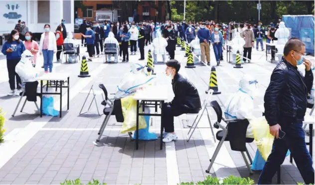  ?? Reuters ?? ↑
A medical worker collects a swab sample from a resident at a makeshift nucleic acid testing site in Beijing on Thursday.