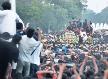  ?? — AFP ?? Fans and party workers gather near the MGR Memorial to get a final glimpse of politician and actress Jayalalith­aa Jayaram as her mortal remains are carried in a procession to her burial place in Chennai.