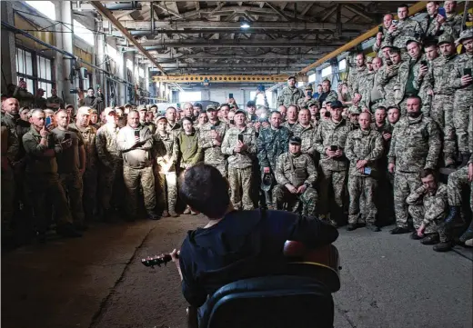  ?? ?? In a temporary base near the Donbas region, Ukrainian singer Vakarchuk performs for soldiers May 16.