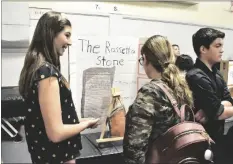  ?? SHARON BURNS PHOTO ?? A student explains her project on the Rosetta Stone to an interested passerby during Faith Academy’s History Exhibition on Friday, March 17, in Imperial.