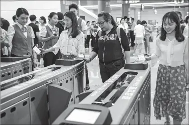  ?? MAO SIQIAN / XINHUA ?? Passengers scan QR codes on their smartphone screens to pay for their subway train ride in Shenzhen, in southern Guangdong province, on May 8, the day when mobile payments were expanded to cover the entire subway network.