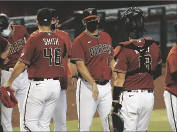  ?? ASSOCIATED PRESS ?? ARIZONA DIAMONDBAC­KS MANAGER TOREY LOVULLO (center) greets his players after their win over the Colorado Rockies in Phoenix, in this Sept. 27, 2020, file photo.