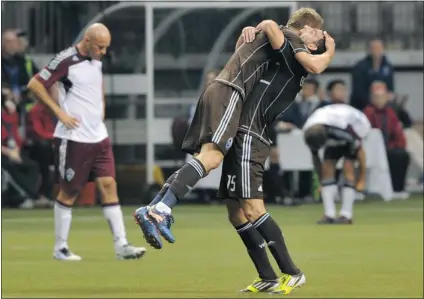  ?? ARLEN REDEKOP/ PNG ?? Vancouver Whitecaps’ Martin Bonjour gets a hug from Jay DeMerit ( left) as the final whistle blows in their 1- 0 win over Colorado Rapids on Saturday. Vancouver Whitecaps’ Sebastien Le Toux ( below) celebrates his second- half goal that won the match.