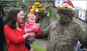  ??  ?? „ Children often fear The Burryman. He wears a suit covered with burrs, decorated with flowers and ferns, and he cannot sit for the whole nine-hour parade.