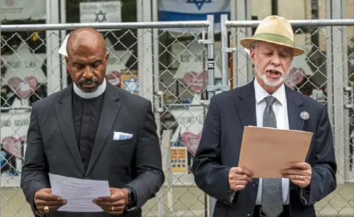  ?? Michael M. Santiago/Post-Gazette ?? Pastor Eric Manning, of Mother Emanuel AME Church, left, and Rabbi Jeffrey Myers, of Tree of Life Congregati­on, read prayers during a May 3 service with survivors of the mass shootings at Emanuel AME Church, in 2015 in South Carolina, and Tree of Life synagogue.