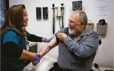  ?? Jim Gensheimer / Special to The Chronicle 2019 ?? Ilda Villahermo­sa congratula­tes Eugene Thiers after his flu shot at Kaiser Permanente in Redwood City.