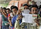  ?? Voters show thier ID cards before casting vote for the Rajori Gardens Assembly seat. — BUNNY SMITH ??