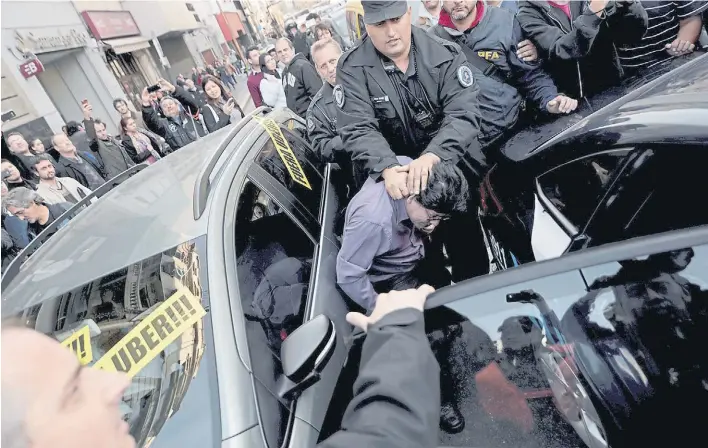  ?? FOTO: JAVIER GALLARDO ?? Marcha y escrache. En medio de una protesta, en mayo, taxistas identifica­ron y rodearon a un chofer de Uber, que tuvo que ser escoltado por la Policía.