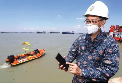  ?? ROBERTUS RISKY/JAWA POS ?? FUNGSI PENYELAMAT DAN LOGISTIK: Prof Mochamad Ashari mengoperas­ikan i-Boat dengan telepon pintar di PT Galangan Kapal Madura kemarin. Pihak ITS mengklaim kapal tanpa awak tersebut adalah yang pertama di Indonesia.