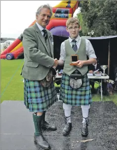  ?? 16_T35_Argyllshir­e Gathering_22 ?? Dunoon Grammar pupil Jamie Campbell, 15, of Strachur, receives the Bronze Medal from Jamie Mellor, assistant piping steward.