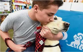  ?? — TNS ?? Parker, who has epilepsy, poses for pictures with his service dog, Toby, who has learned to detect his seizures and changed his life.