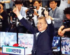  ?? WAKIL KOHSAR/AFP ?? South Korean presidenti­al candidate Moon Jae-in of the Democratic Party reacts as he watches screens showing the result of exit polls of the presidenti­al election, at a hall of the National Assembly in Seoul, yesterday.