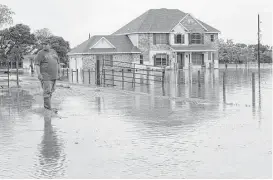  ?? Melissa Phillip / Houston Chronicle file ?? Donald Treichel looks at the water along Cypress Rosehill Road in Cypress during the April floods. County Commission­er Steve Radack recently proposed a tax increase to pay for more flood-control projects.