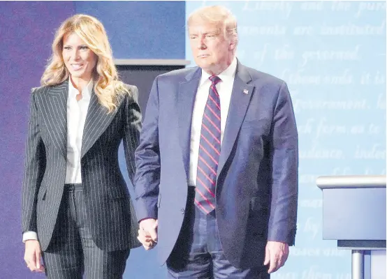  ?? AP ?? In this September 29, 2020, file photo, US President Donald Trump and First Lady Melania Trump hold hands on stage after the first Presidenti­al Debate at Case Western University and Cleveland Clinic in Cleveland, Ohio. President Trump and First Lady Melania Trump have tested positive for the coronaviru­s, the president tweeted early Friday.