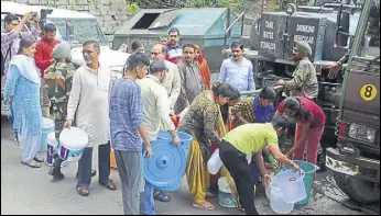  ?? DEEPAK SANSTA/HT ?? People filling water from an army tanker at Vikas Nagar in Shimla on Saturday.